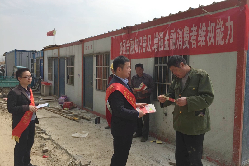 志愿者向务工人员发放宣传手册.jpg