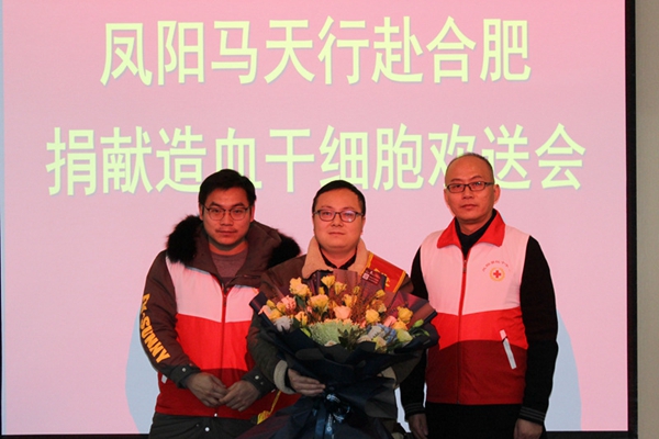 凤阳县造血干细胞捐献志愿者向马天行（中）献花.jpg